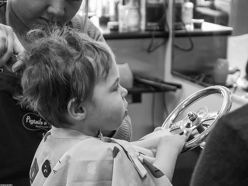 Child in a fun race car style salon chair